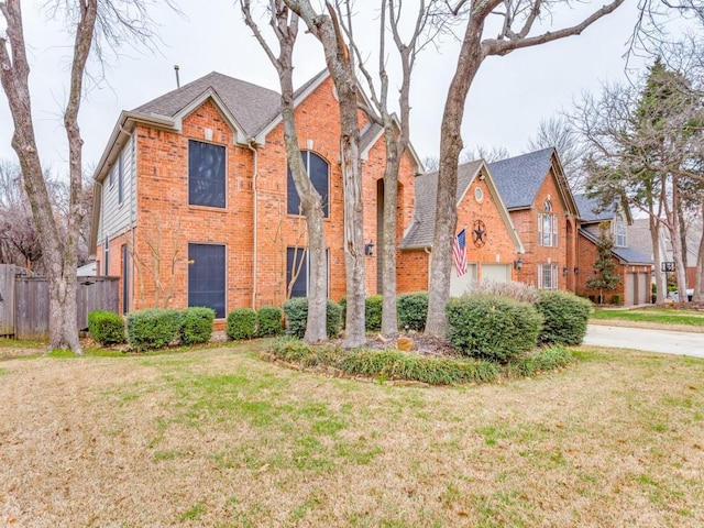 traditional-style home featuring brick siding, fence, and a front lawn