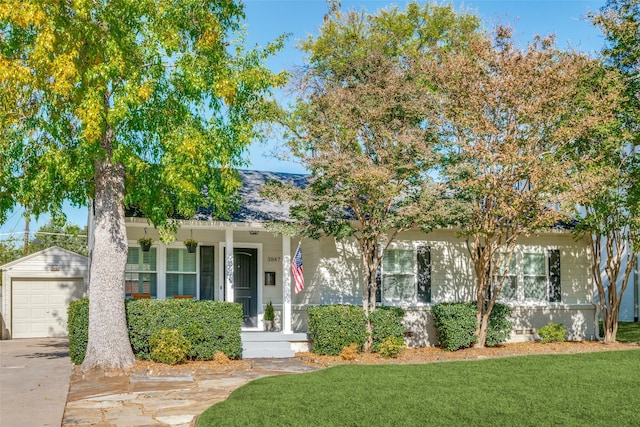 view of front facade with covered porch, concrete driveway, and a front lawn