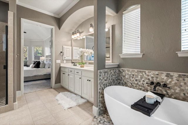 ensuite bathroom with tile patterned flooring, connected bathroom, vanity, a soaking tub, and crown molding