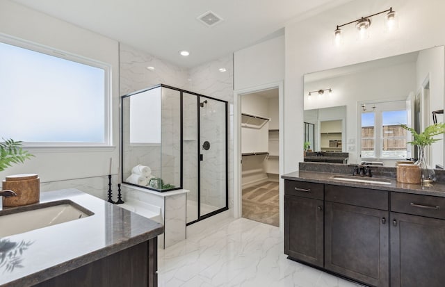 full bathroom featuring visible vents, a sink, marble finish floor, a shower stall, and two vanities