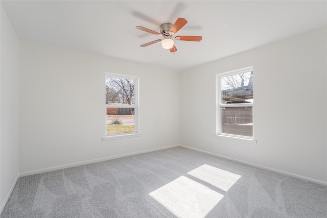 spare room with plenty of natural light, baseboards, and carpet flooring