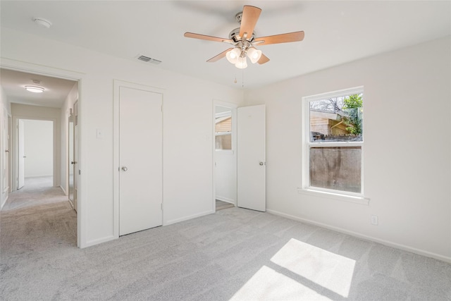 unfurnished bedroom with light colored carpet, a ceiling fan, baseboards, visible vents, and a closet