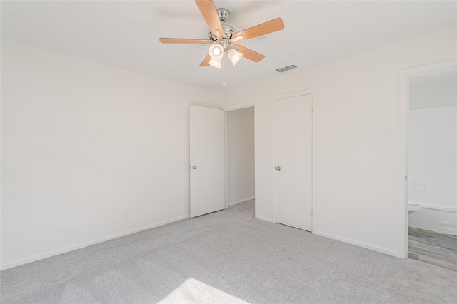 unfurnished bedroom featuring light carpet, ceiling fan, visible vents, and baseboards