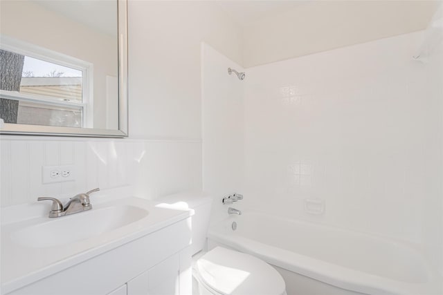 bathroom with washtub / shower combination, wainscoting, vanity, and toilet