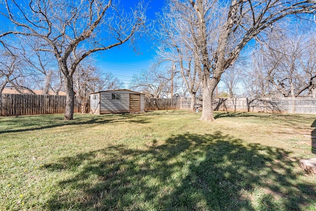 view of yard featuring a storage unit, an outdoor structure, and a fenced backyard