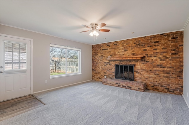 unfurnished living room featuring carpet floors, a ceiling fan, baseboards, ornamental molding, and a brick fireplace