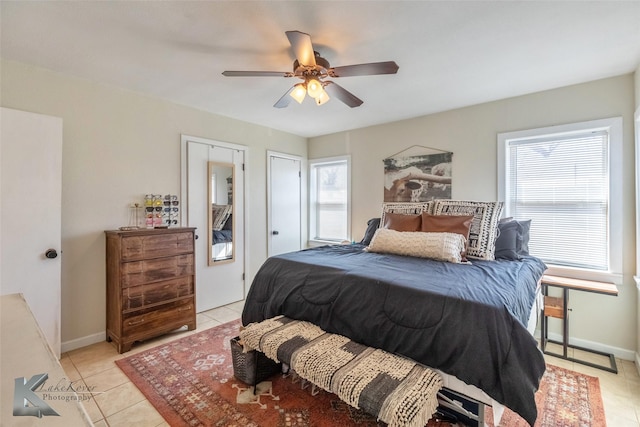 bedroom with ceiling fan, baseboards, and light tile patterned flooring