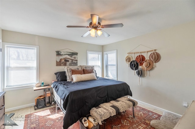 bedroom with light tile patterned flooring, ceiling fan, and baseboards