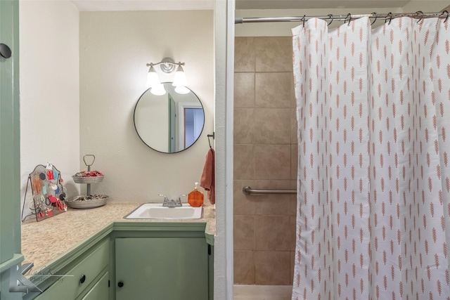 bathroom featuring tiled shower and vanity