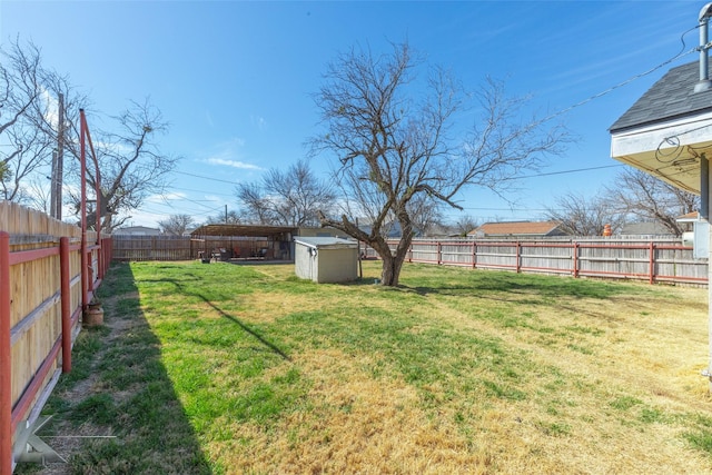 view of yard featuring a storage unit, an outdoor structure, and a fenced backyard