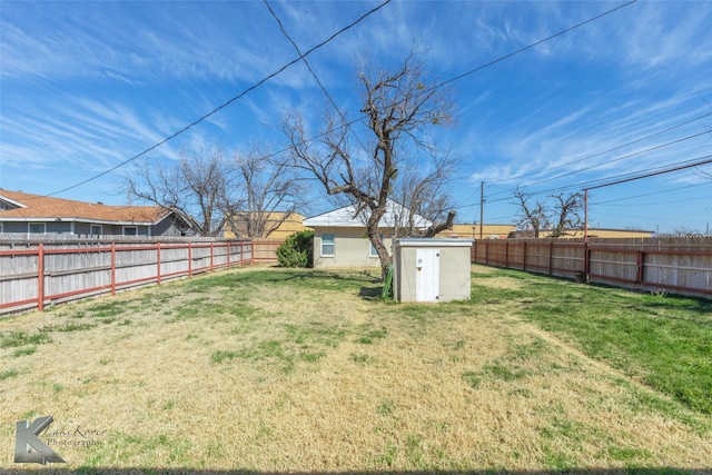 view of yard with a fenced backyard, an outdoor structure, and a shed