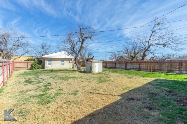 view of yard with an outbuilding, a storage shed, and a fenced backyard