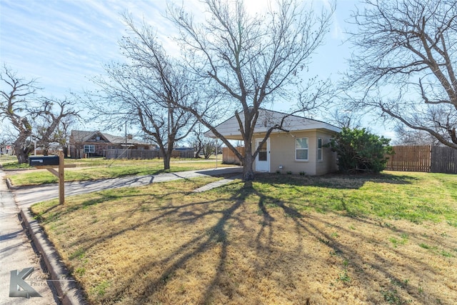 view of front of house with a front yard and fence