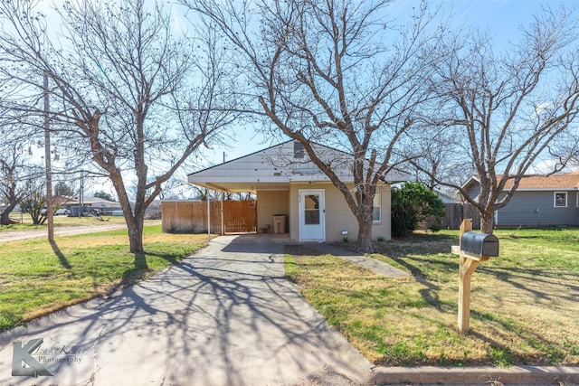 view of front of home featuring a carport, a front yard, driveway, and fence