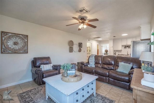 living room with baseboards, visible vents, a ceiling fan, and light tile patterned flooring