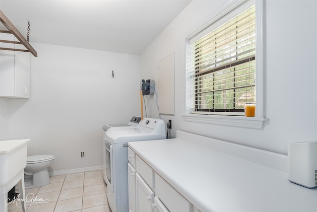 laundry room featuring washing machine and dryer, baseboards, and light tile patterned flooring