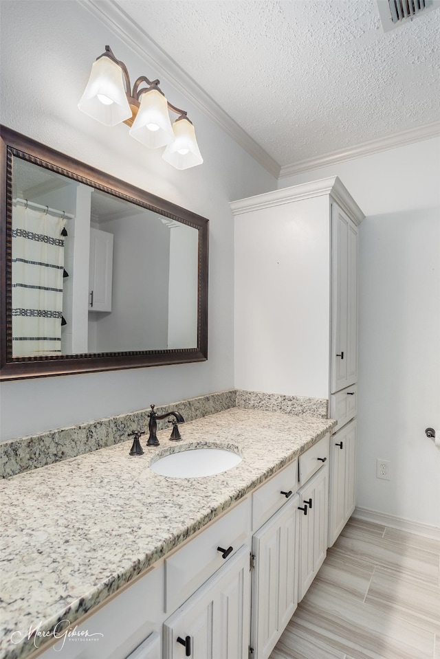 full bathroom with visible vents, ornamental molding, a textured ceiling, and vanity