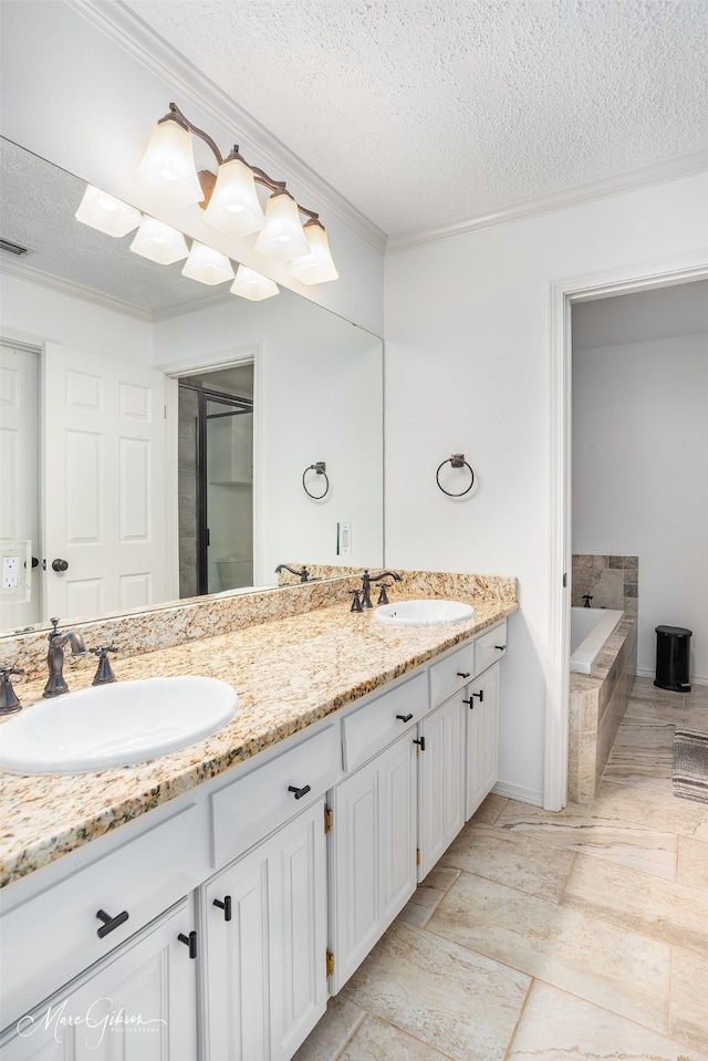 full bathroom with ornamental molding, a sink, a textured ceiling, and double vanity