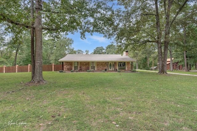 ranch-style house featuring brick siding, a front lawn, and fence