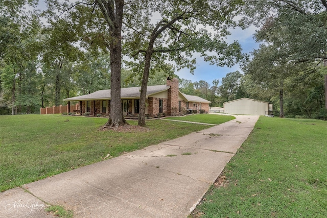 single story home featuring a front lawn, a chimney, an outdoor structure, and brick siding