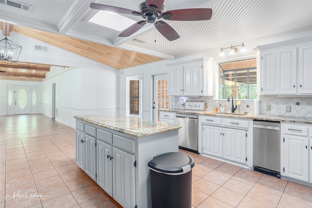 kitchen featuring light tile patterned floors, vaulted ceiling with beams, a sink, a kitchen island, and stainless steel dishwasher