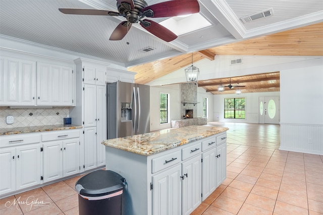 kitchen featuring open floor plan, light tile patterned flooring, stainless steel fridge, and visible vents