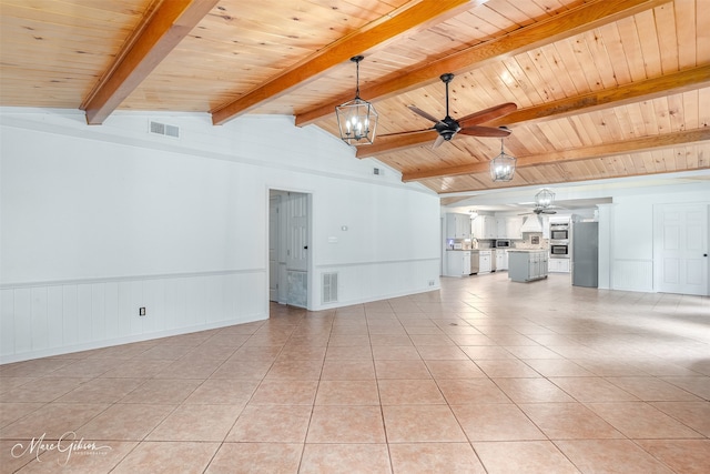 unfurnished living room with ceiling fan with notable chandelier, visible vents, lofted ceiling with beams, and light tile patterned flooring