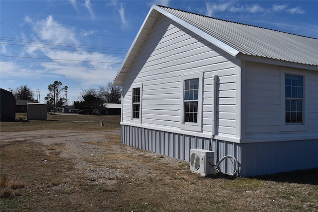 view of side of property with ac unit and metal roof