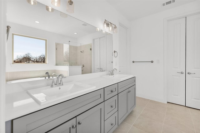 full bath featuring tile patterned flooring, a sink, visible vents, a shower stall, and double vanity