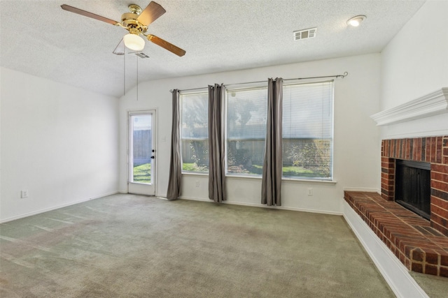 living area with carpet, vaulted ceiling, a fireplace, and visible vents