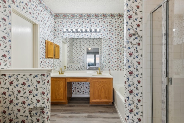 bathroom with a shower stall, a sink, a garden tub, and wallpapered walls