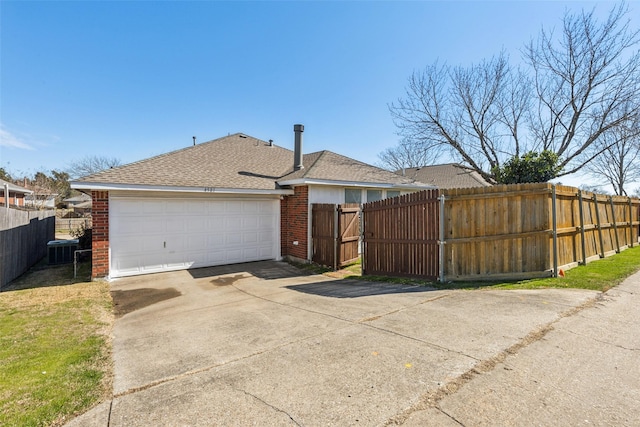 back of house with a shingled roof, a gate, fence, and brick siding