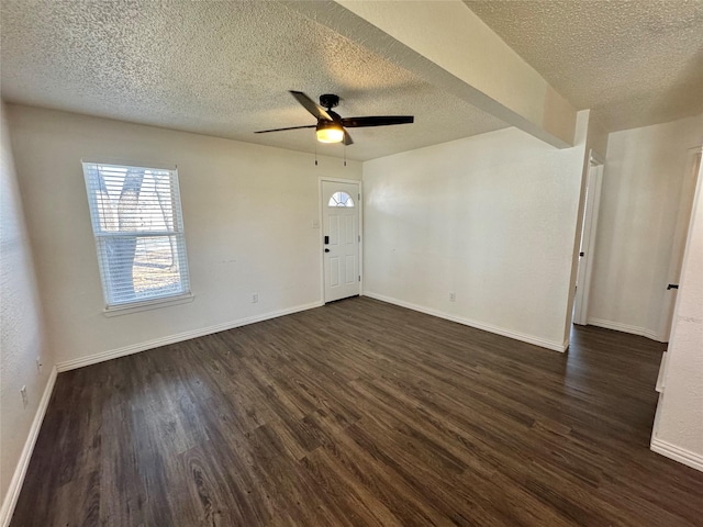 interior space with ceiling fan, baseboards, dark wood finished floors, and a textured ceiling