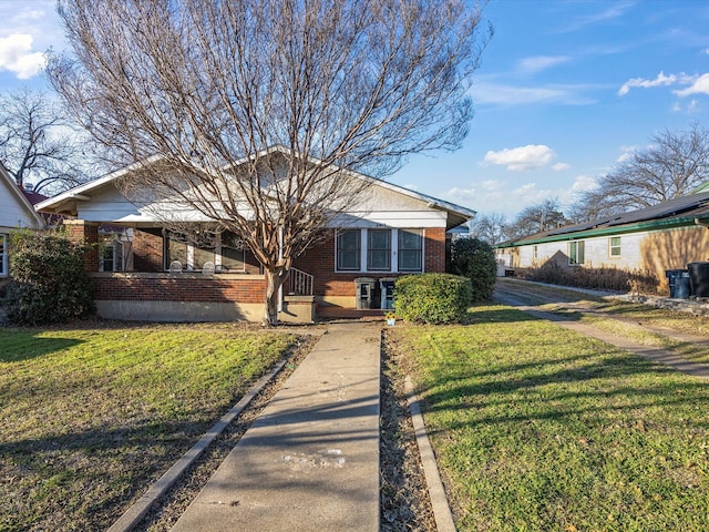 bungalow-style home with brick siding and a front lawn