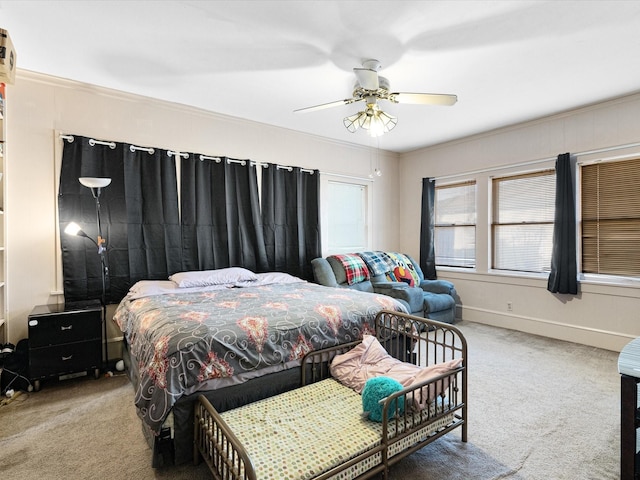 bedroom with carpet floors, baseboards, ornamental molding, and ceiling fan