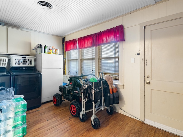 garage with visible vents, washer and clothes dryer, and freestanding refrigerator