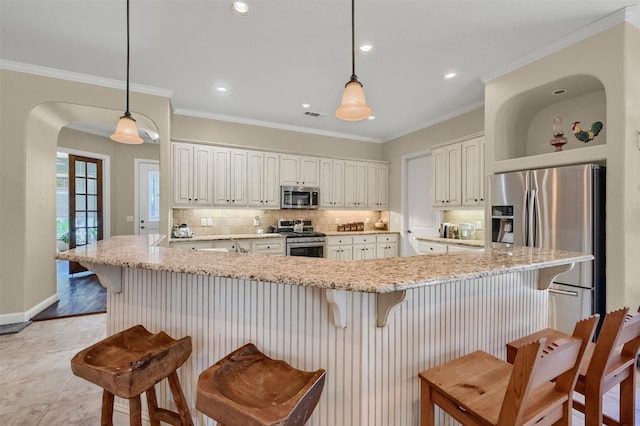 418 Navajo Trl, Gainesville, TX 76240 - kitchen featuring appliances with stainless steel finishes, crown molding, decorative backsplash, and light stone countertops