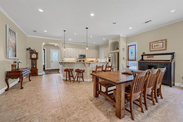 418 Navajo Trl, Gainesville, TX 76240 - dining area featuring light tile patterned floors, baseboards, visible vents, arched walkways, and ornamental molding