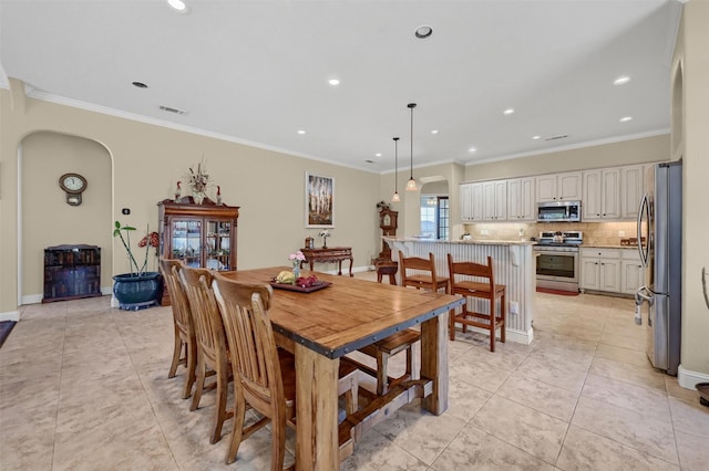 418 Navajo Trl, Gainesville, TX 76240 - dining room with arched walkways, light tile patterned floors, visible vents, baseboards, and ornamental molding