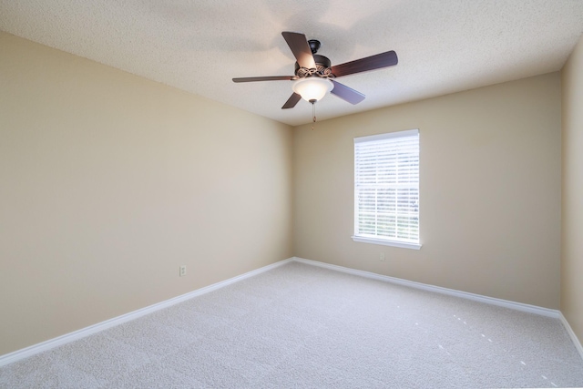 unfurnished room featuring carpet flooring, ceiling fan, a textured ceiling, and baseboards