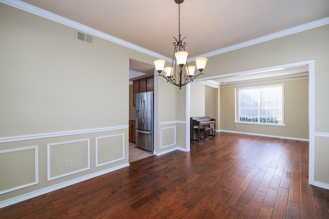 unfurnished dining area featuring an inviting chandelier, crown molding, visible vents, and dark wood-type flooring