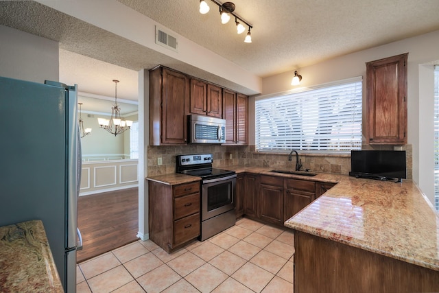 kitchen featuring light tile patterned floors, visible vents, decorative backsplash, appliances with stainless steel finishes, and a sink