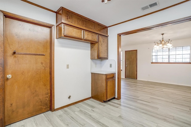 kitchen with a notable chandelier, visible vents, baseboards, light wood-type flooring, and brown cabinetry