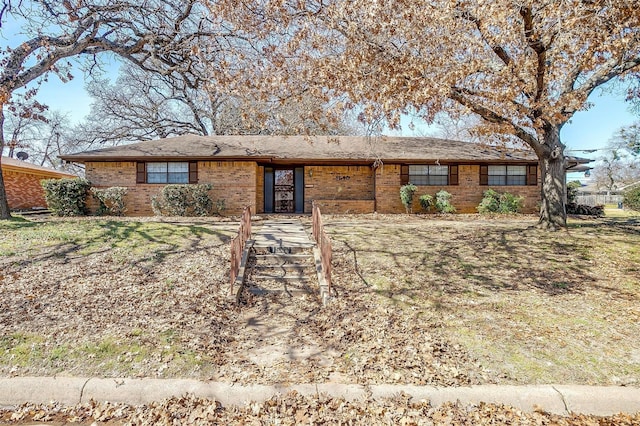 ranch-style house featuring brick siding