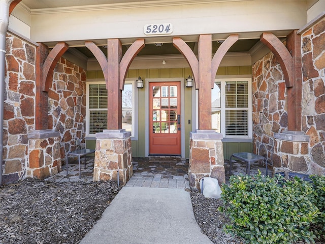 entrance to property with stone siding, a porch, and brick siding