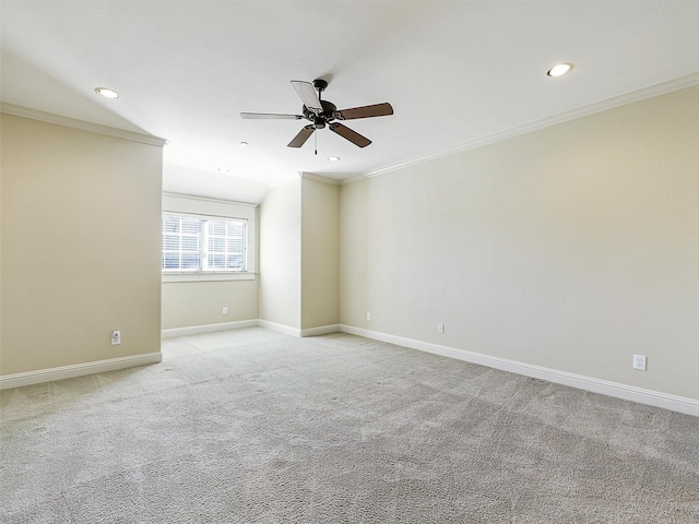 spare room featuring light carpet, crown molding, and baseboards