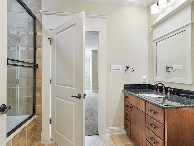 bathroom with tile patterned flooring, vanity, baseboards, tiled shower / bath, and crown molding