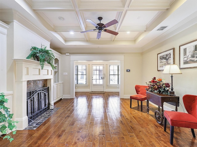 living area with coffered ceiling, beam ceiling, visible vents, and hardwood / wood-style floors