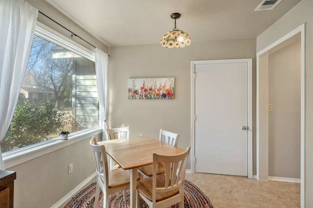 dining area featuring light carpet, baseboards, and visible vents