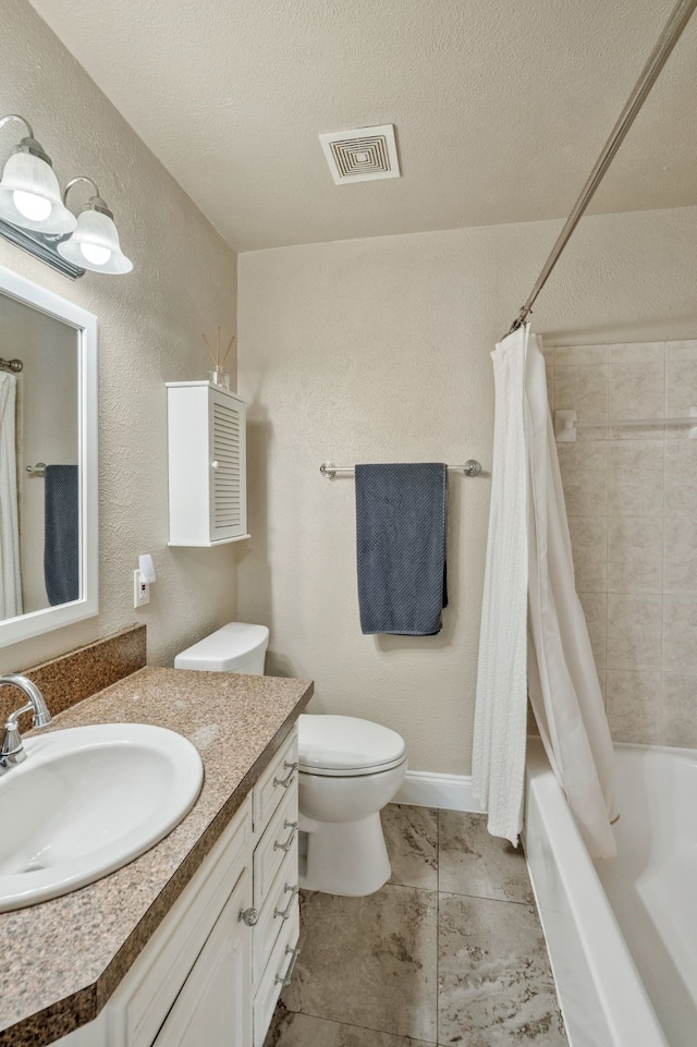 bathroom featuring toilet, vanity, visible vents, and a textured wall